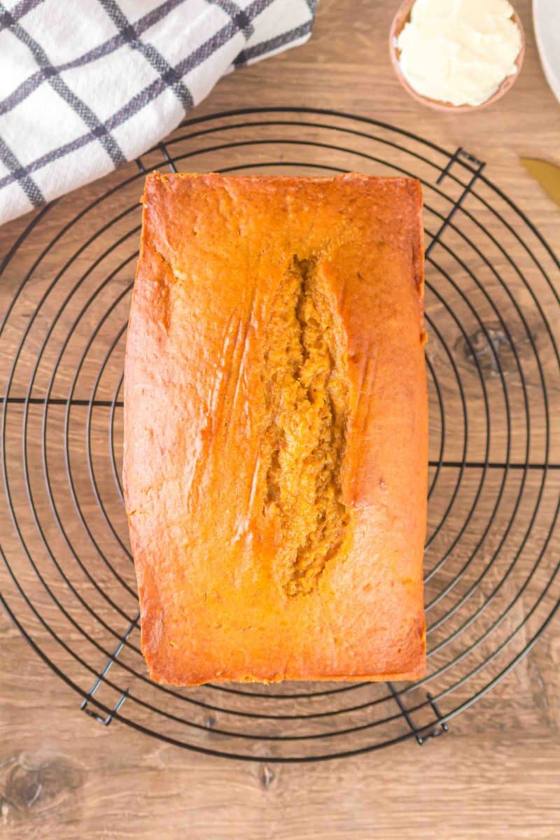 Top down view of a loaf of quick pumpkin bread on a cooling rack - Hostess At Heart