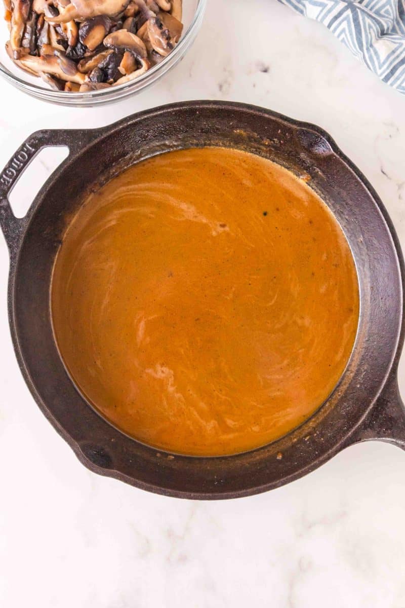 An image showing cooked gravy in a cast iron skillet - Hostess At Heart