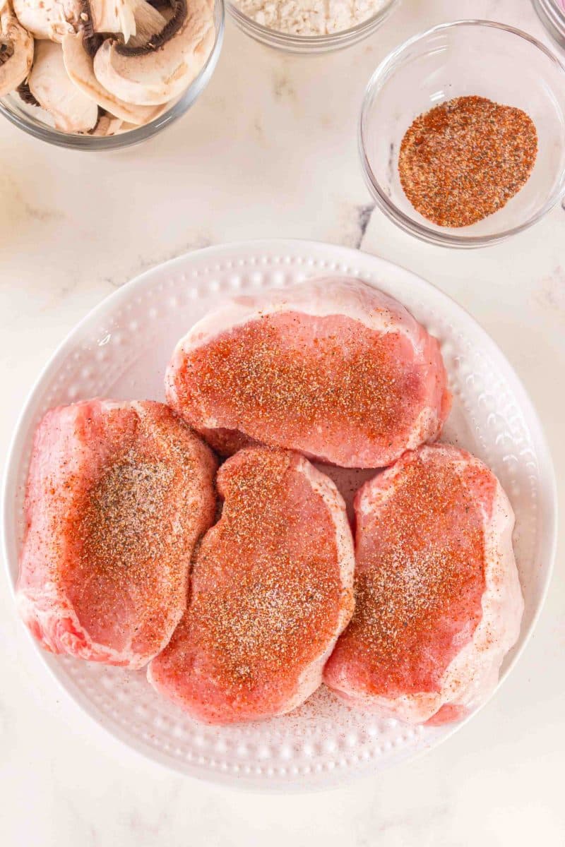 Top down view of a plate of seasoned pork loin chops - Hostess At Heart