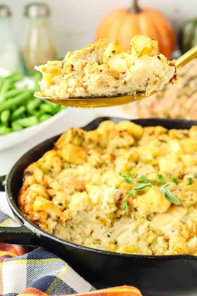 A serving spoon filled with a crispy herbed stuffing recipe - Hostess At Heart