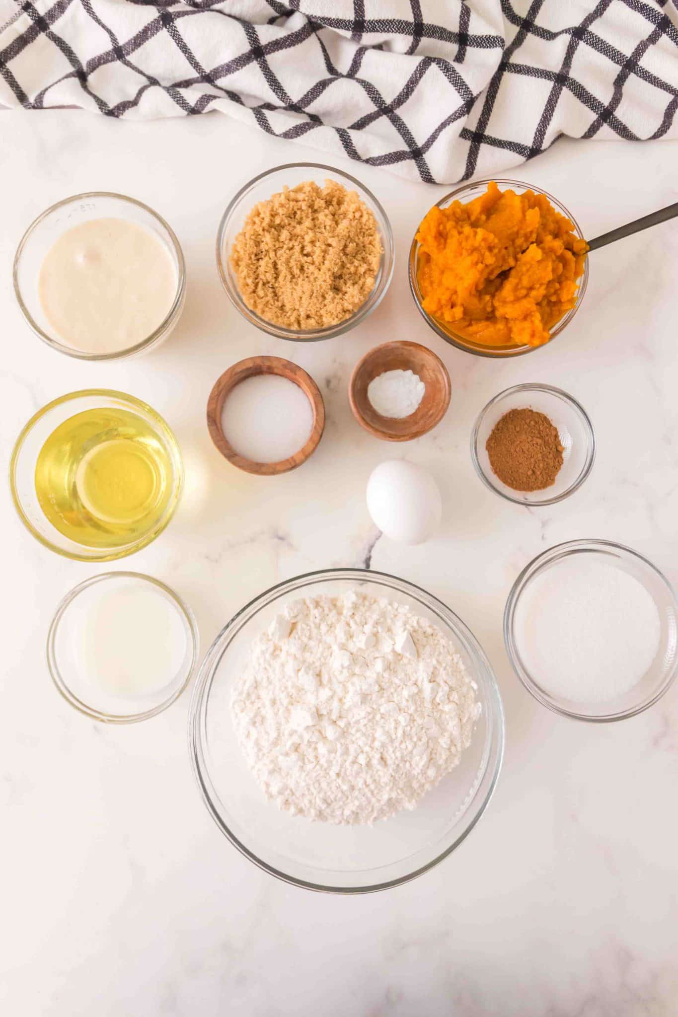 Sourdough pumpkin bread recipe ingredients: all-purpose flour, baking powder, salt, baking soda, pumpkin pie spice, oil, egg, sourdough starter discard, white sugar, brown sugar, pumpkin puree, and milk. - Hostess At Heart