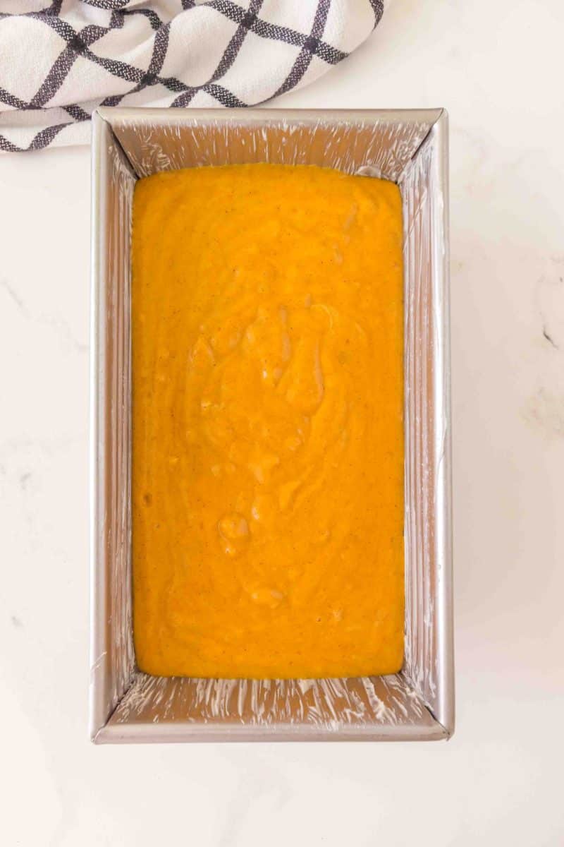 Top down view of a loaf pan filled with sourdough pumpkin bread batter. Hostess At Heart