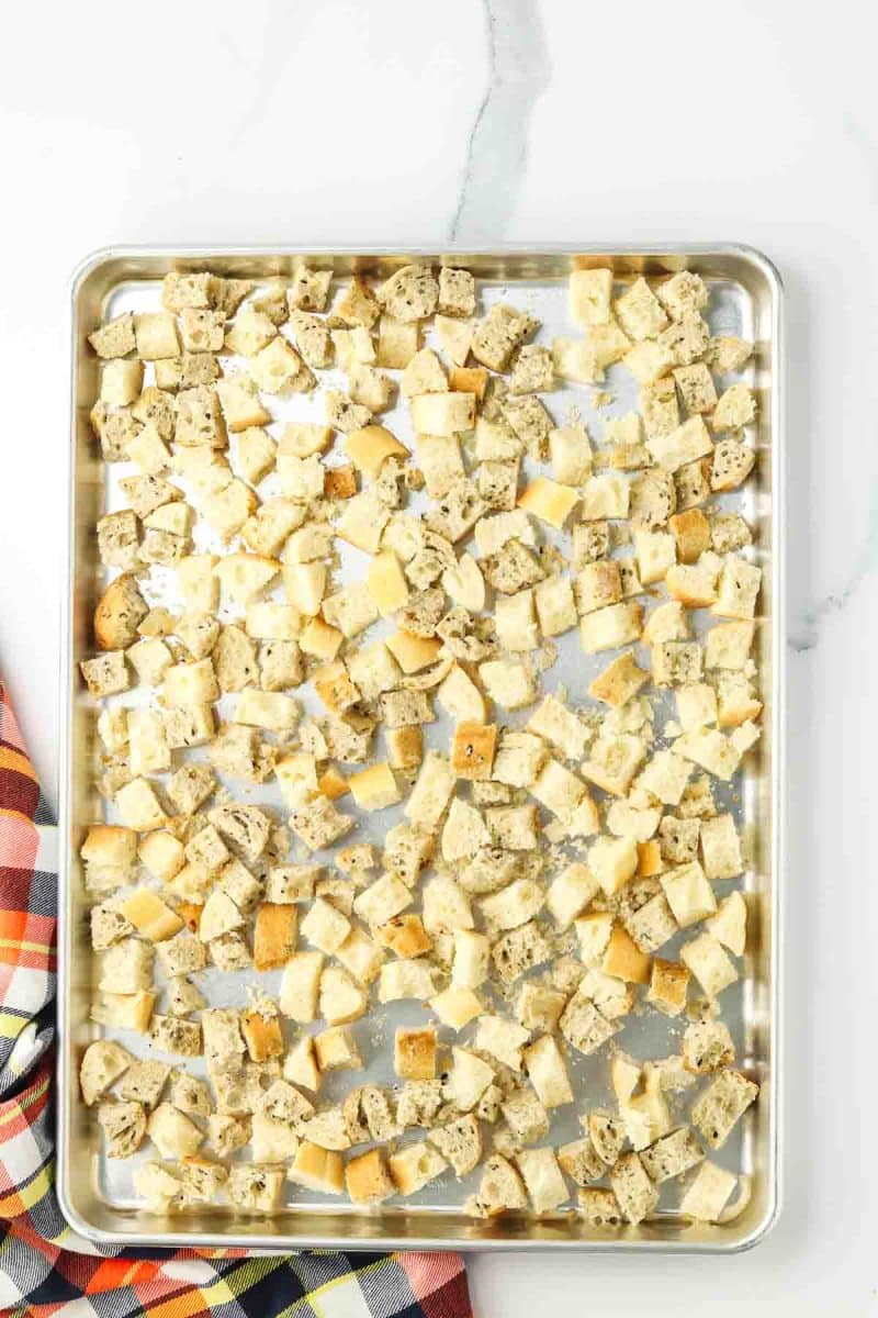A baking sheet filled with toasted bread cubes. Hostess At Heart