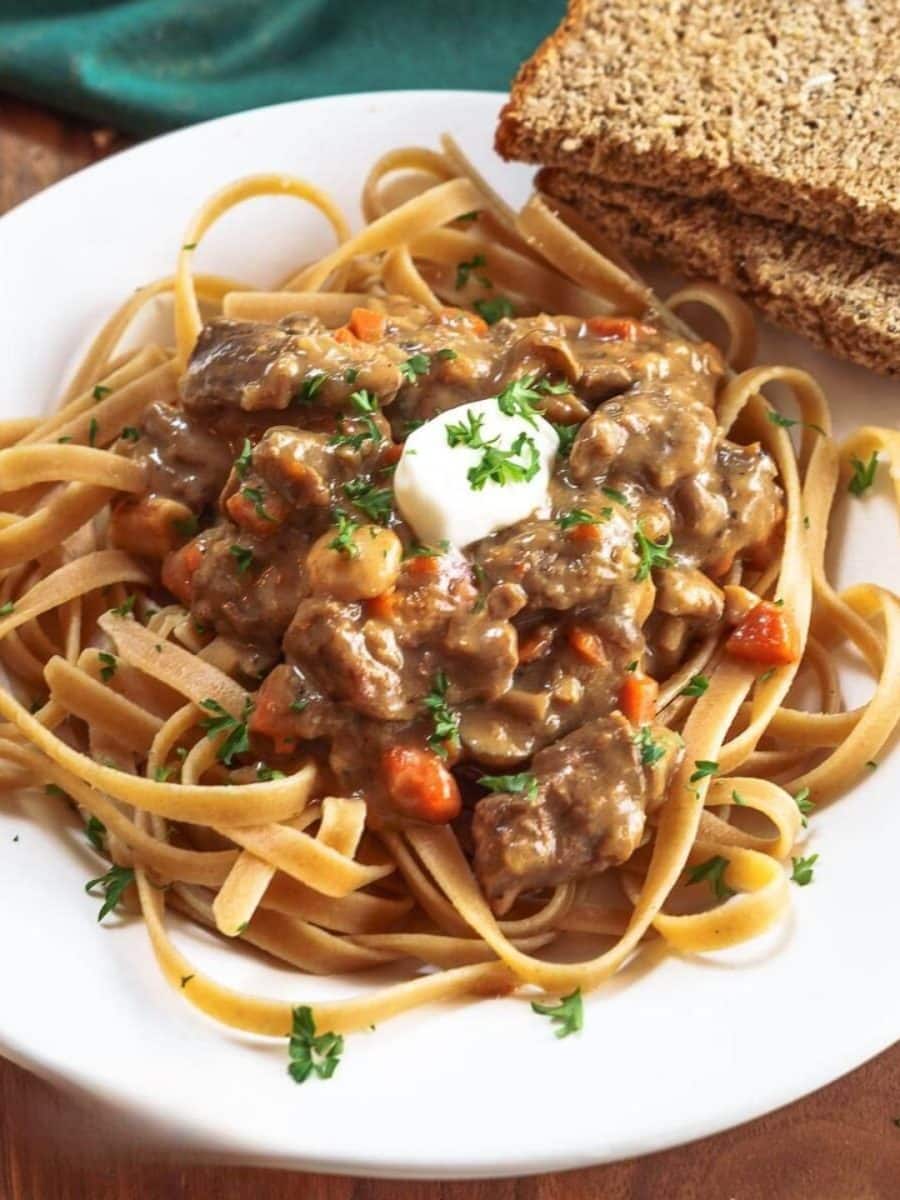 Top down view of a stroganoff recipe with carrots served over whole grain pasta - Hostess At Heart