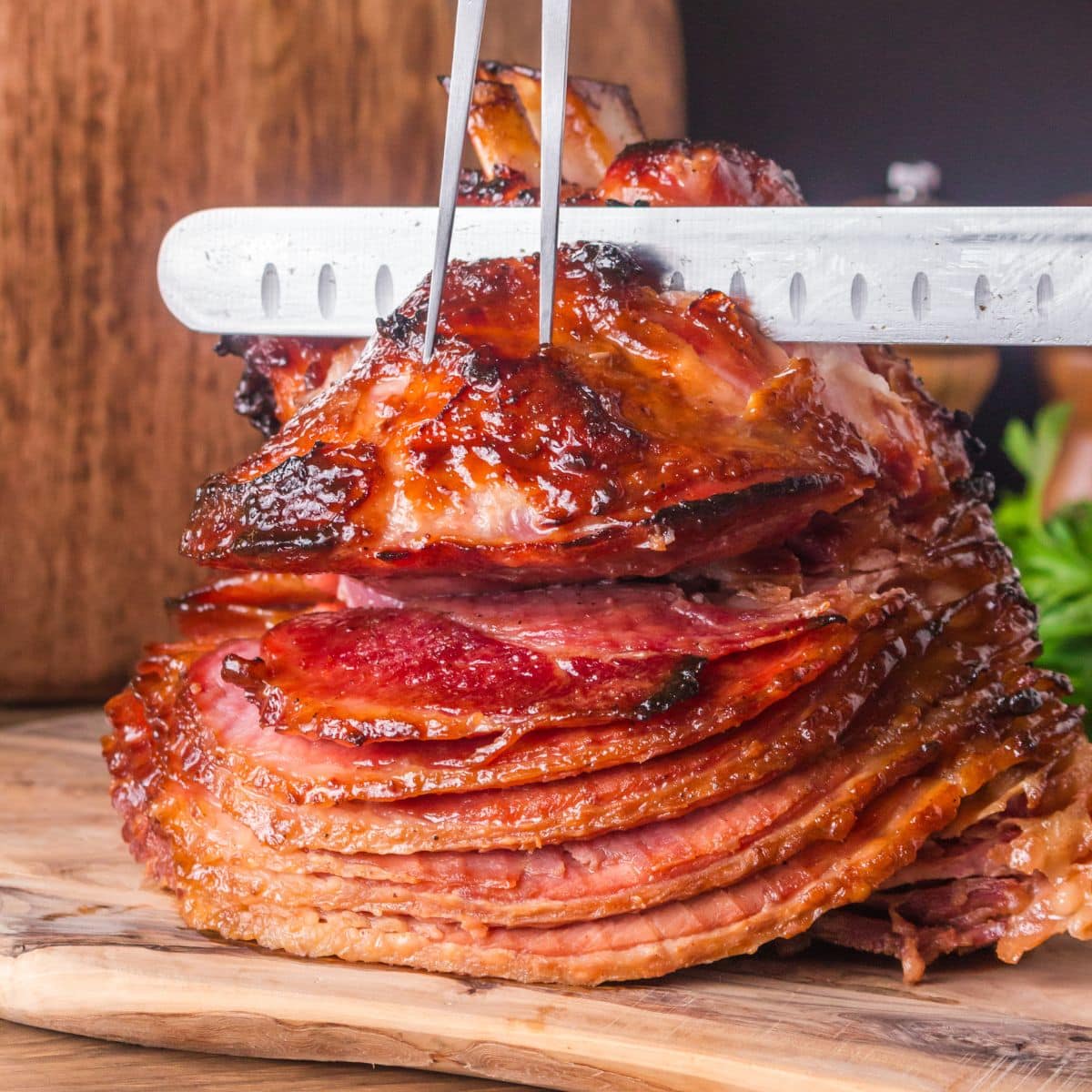 Whole honey baked ham on wooden cutting board ready to slice showing caramelized exterior - Hostess At Heart