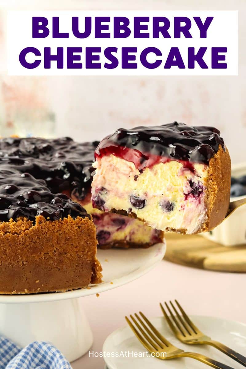 Creamy slice of blueberry cheesecake on spatula showing graham cracker crust and blueberry-studded filling - Hostess At Heart