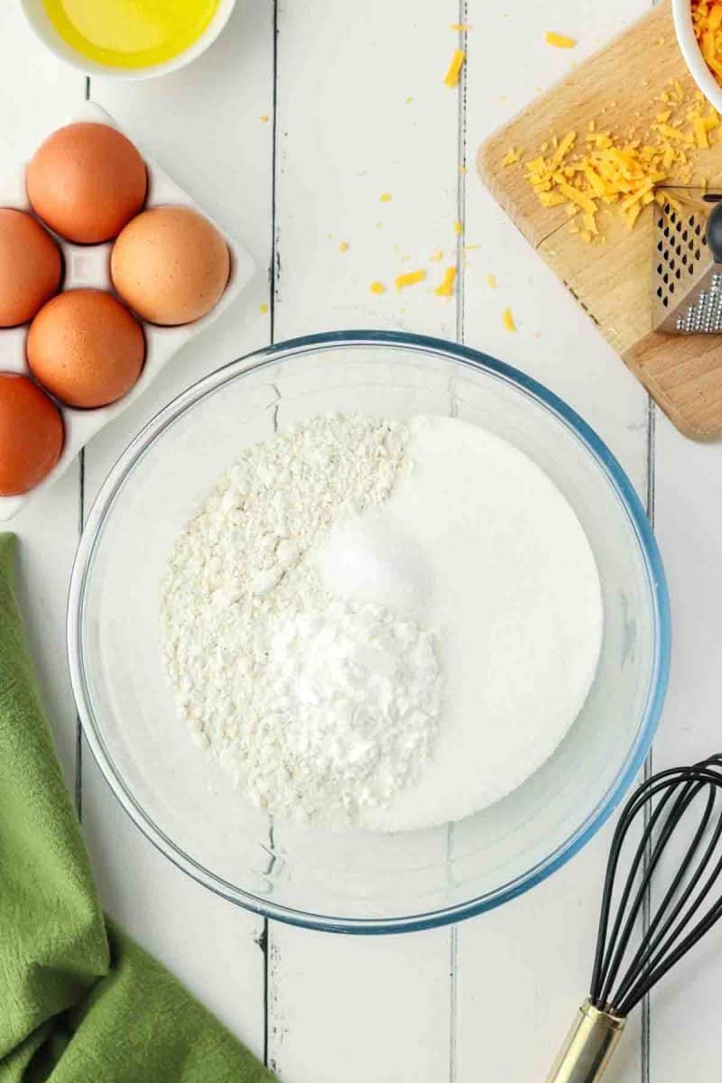 Whisking flour, baking powder, sugar and salt in bowl for cheddar muffins - Hostess At Heart