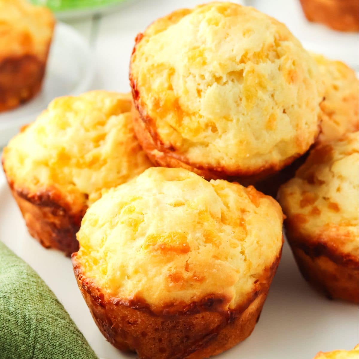 Fluffy golden brown savory cheese muffins sitting on a platter - Hostess At Heart