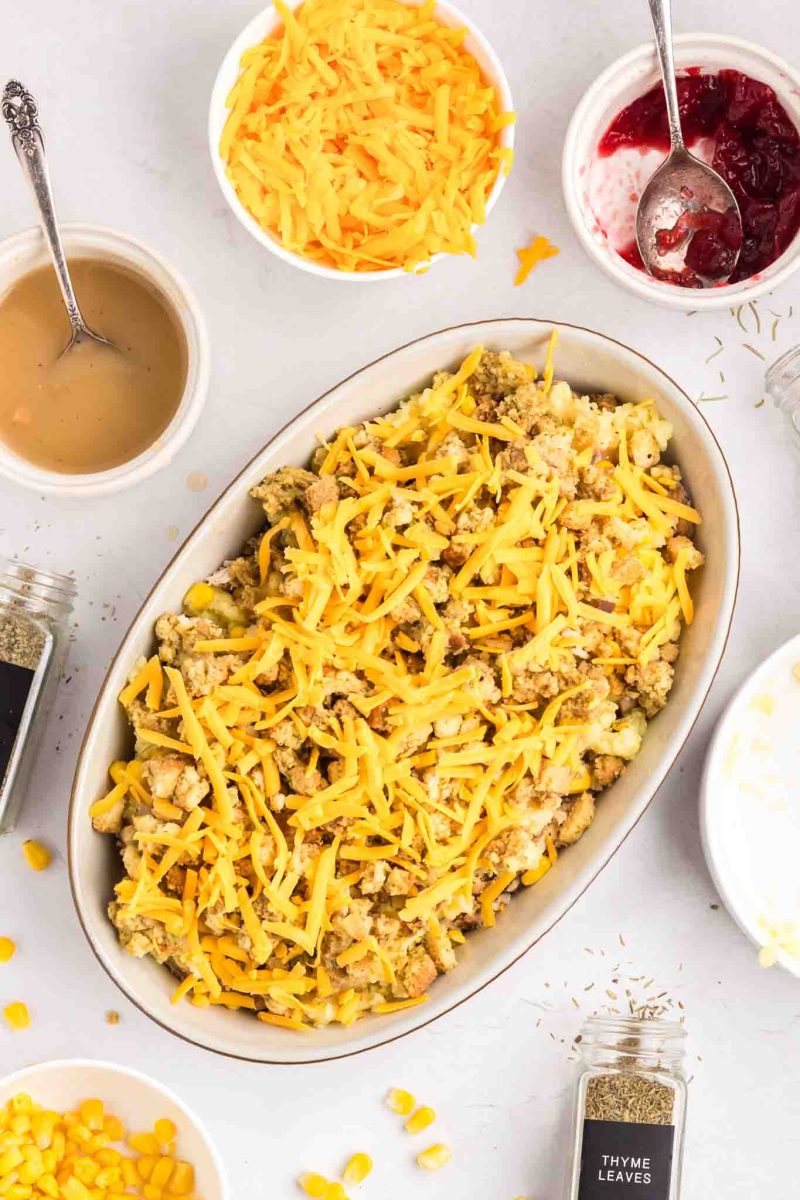 Top down view of a layered Thanksgiving Leftover Casserole sprinkled with cheese - Hostess At Heart