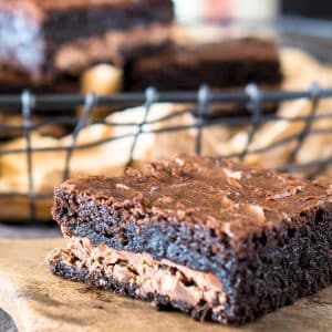 Closeup table view of a single dark chocolate symphony candy bar brownie showing a crunchy toffee candy bar baked in the middle of a moist chocolate brownie - Hostess At Heart