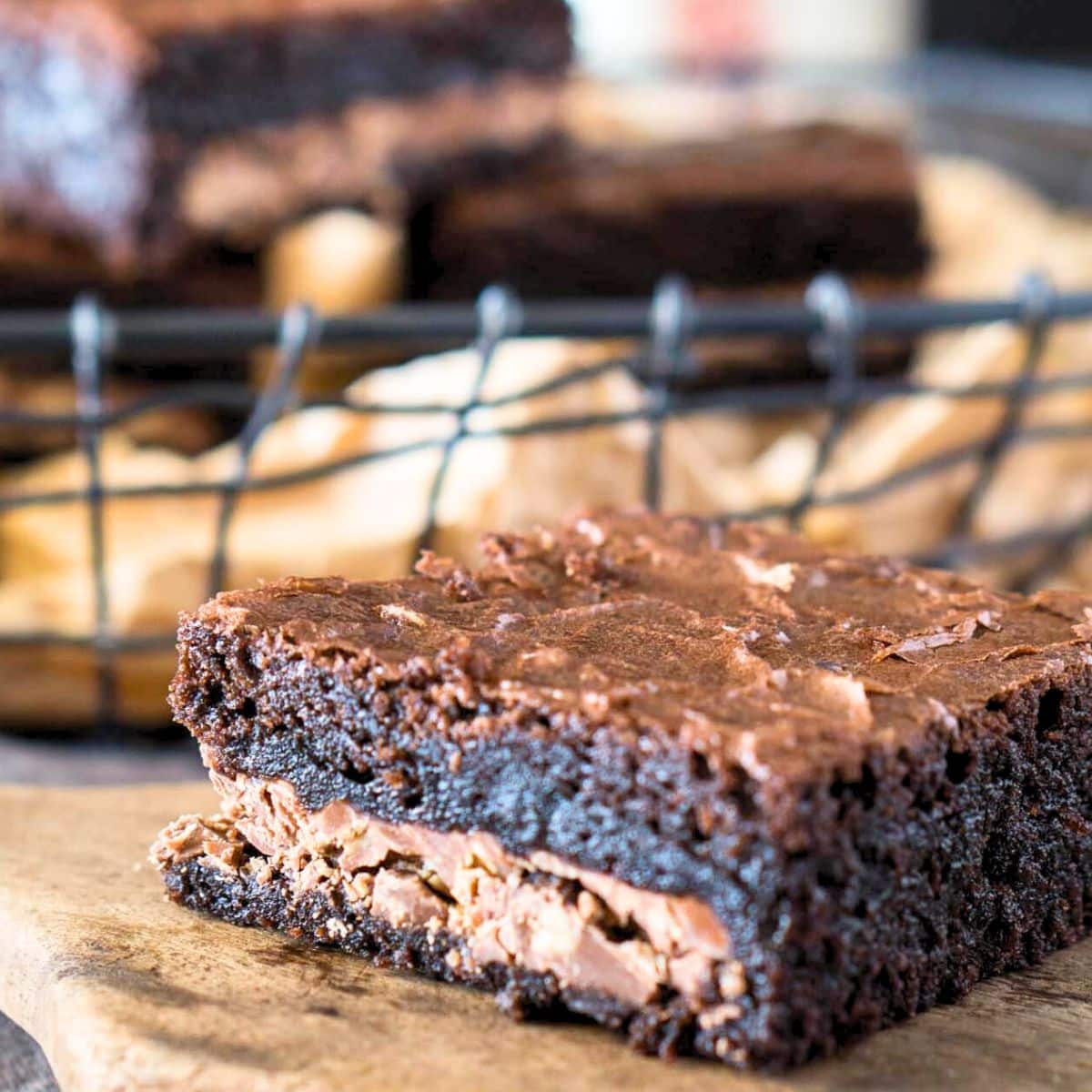 Closeup table view of a single dark chocolate symphony candy bar brownie showing a crunchy toffee candy bar baked in the middle of a moist chocolate brownie - Hostess At Heart