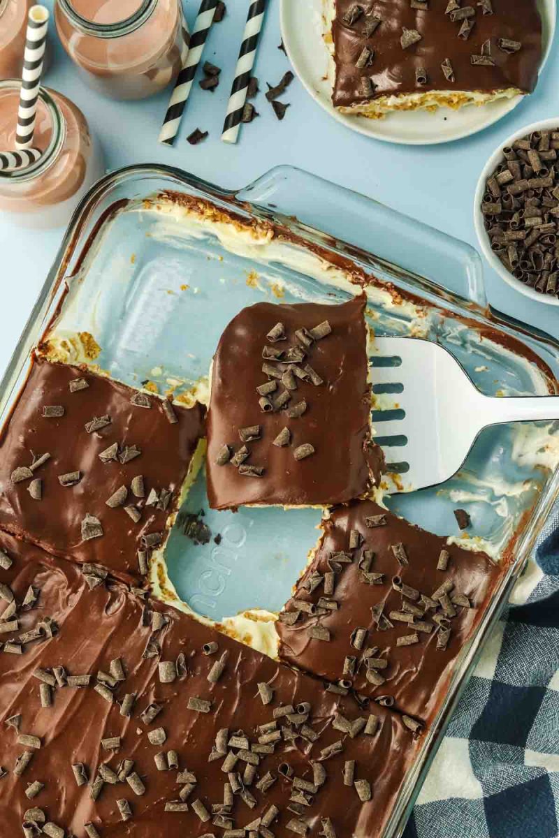 9x13 pan of chocolate eclair cake cut into squares ready to serve - Hostess At Heart