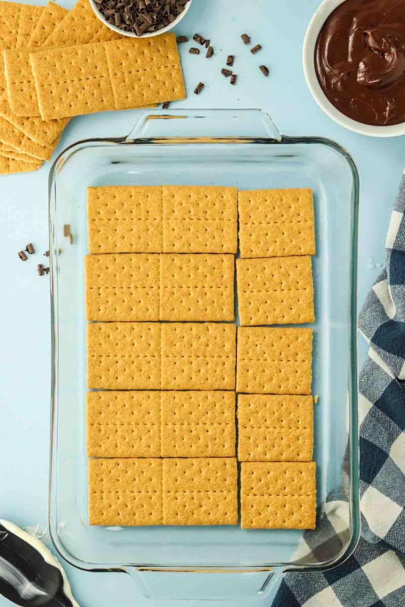 A layer of graham crackers lining the bottom of a 9x13 baking dish - Hostess At Heart