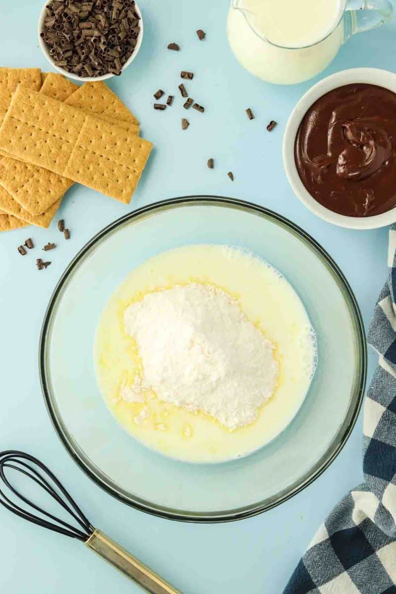 Adding instant vanilla pudding mix with milk in a large mixing bowl - Hostess At Heart