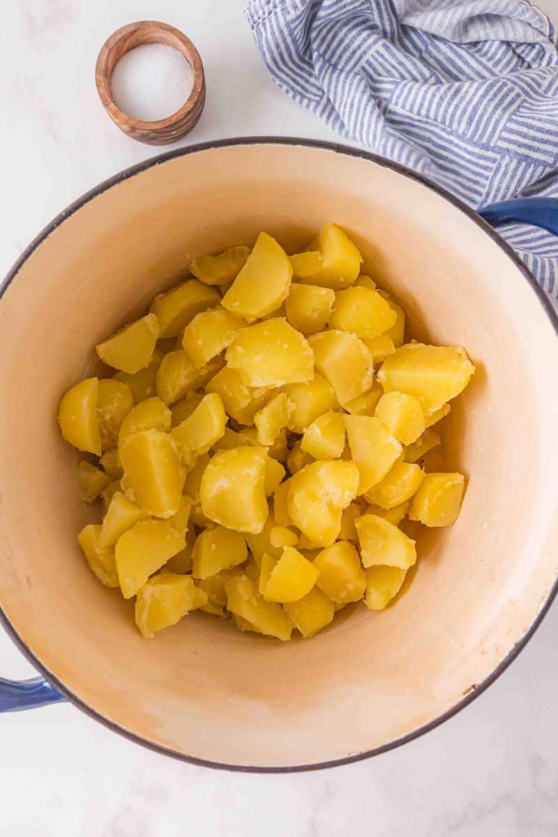 Top down view of hot cooked and drained Yukon Potatoes in a pot - Hostess At Heart