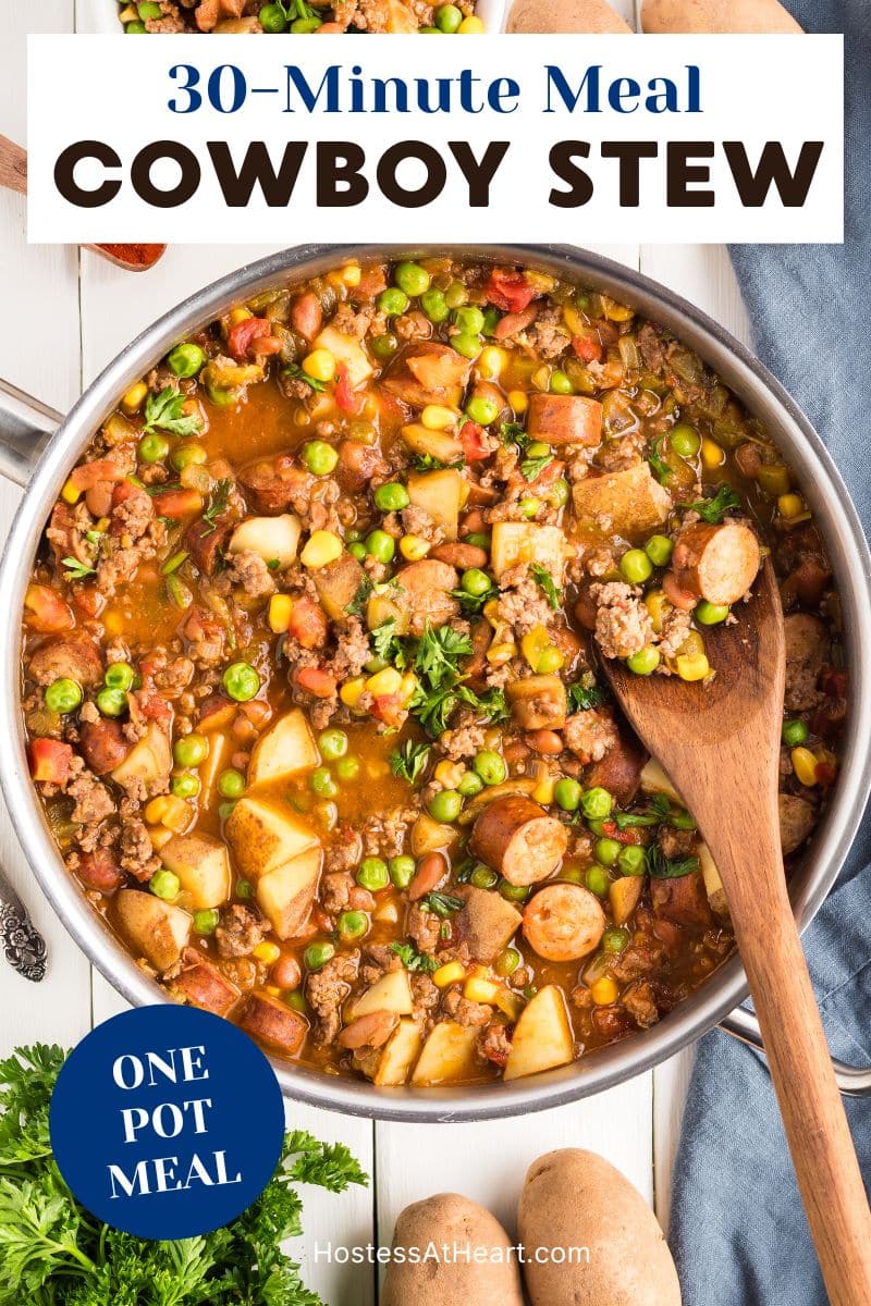 Top down view of a skillet of simmering cowboy stew filled with ground beef, sausage, potatoes, corn, peas, and beans in a tomato-based broth - Hostess At Heart