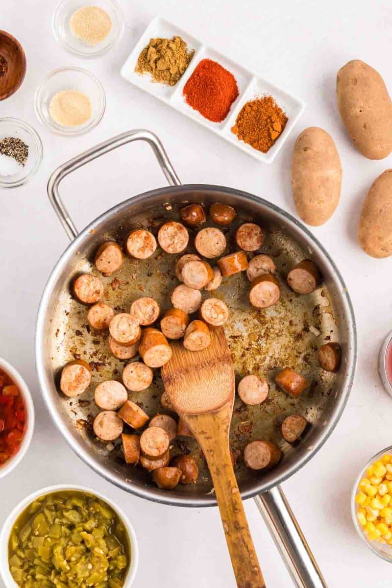 Thick slices of sausages browning in a skillet - Hostess At Heart