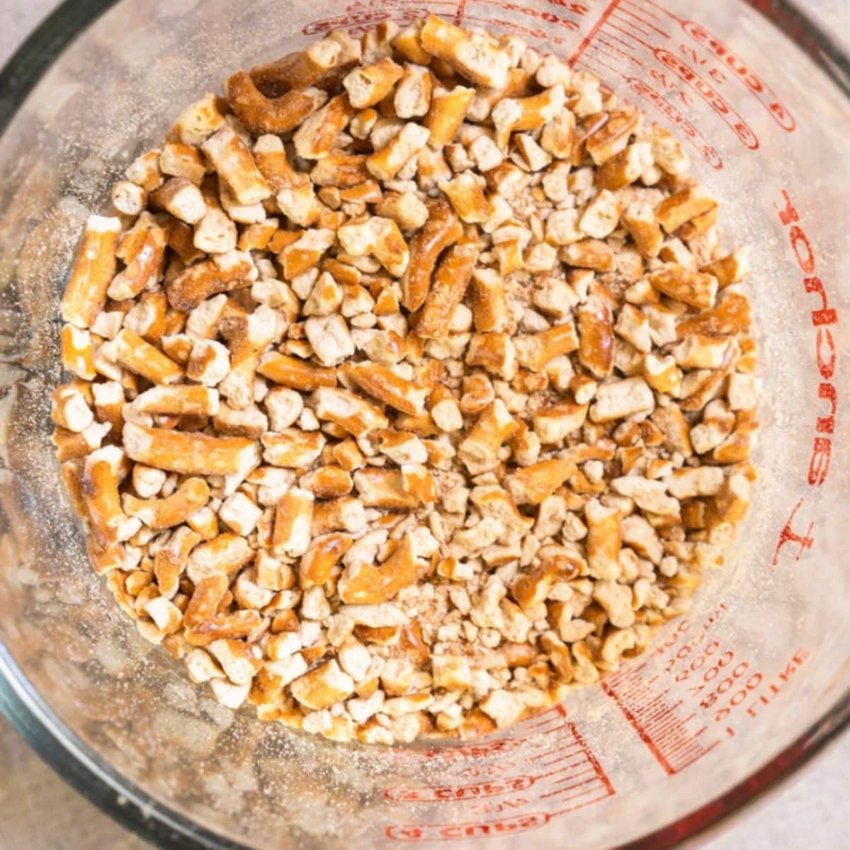 Crushed pretzels in measuring cup for no bake bars - Hostess At Heart