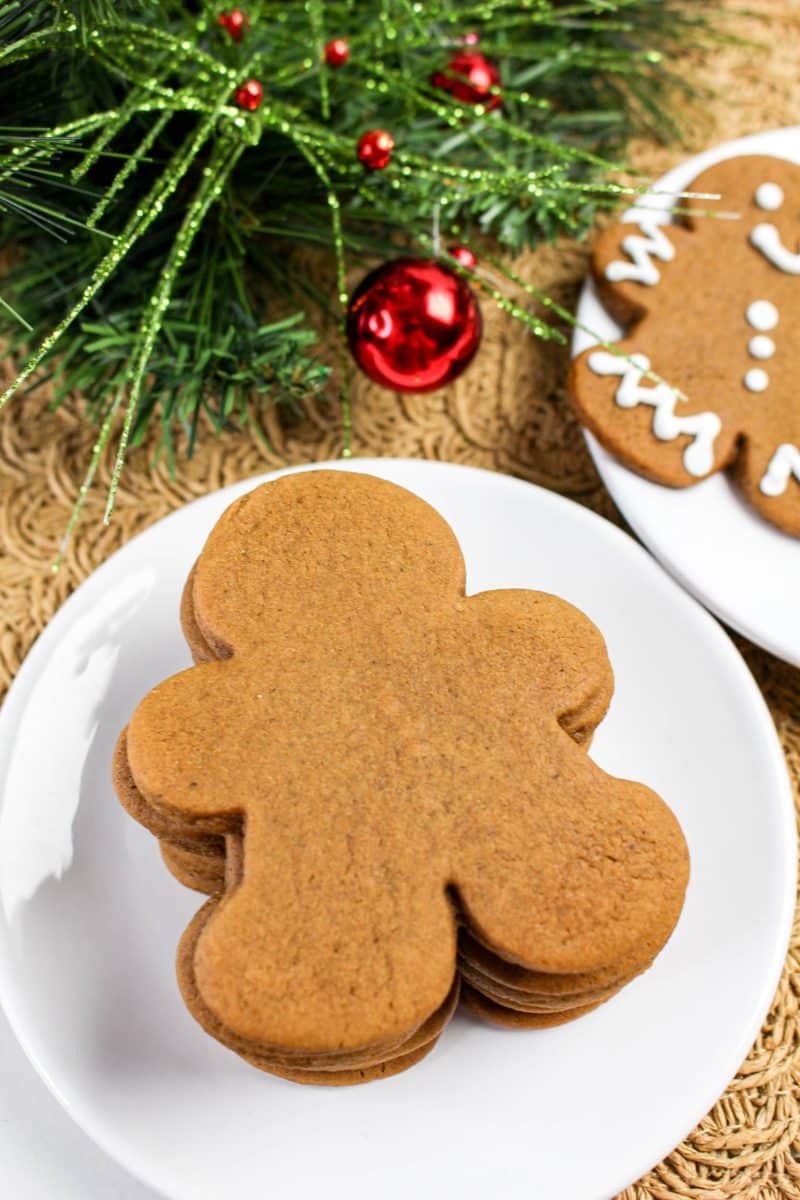 A plate holding a stack of undecorated gingerbread cut out cookies - Hostess At Heart
