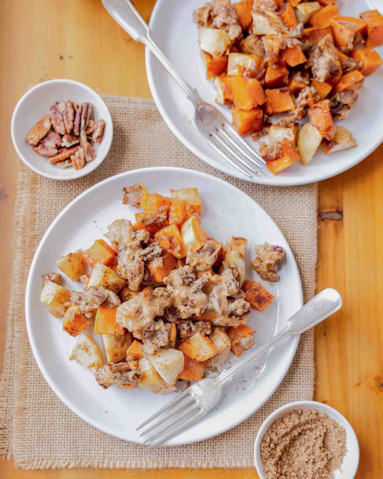 Top down view of individual serving of sweet potato apple casserole on white plates - Hostess At Heart