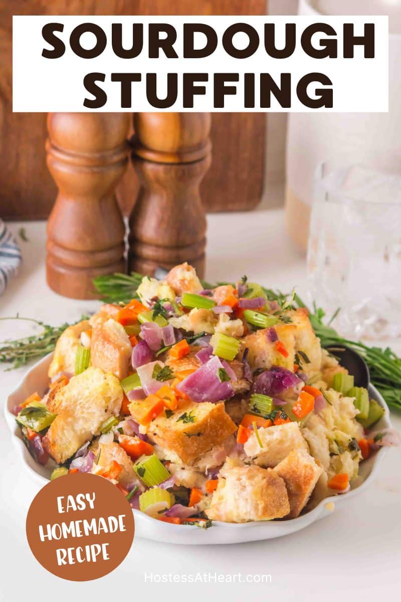 An image for Pinterest of Golden brown sourdough stuffing in a white baking dish with crispy edges and fresh herbs - Hostess At Heart