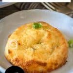 An image for Pinterest of a baked crispy mashed potato cake on a plate. Hostess At Heart