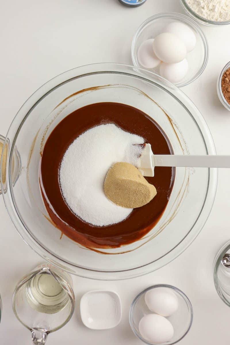 White and brown sugar added to a melted chocolate mixture in a mixing bowl - Hostess At Heart