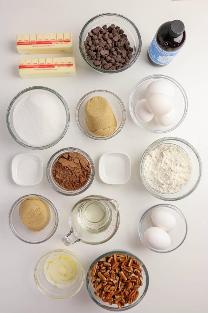 Ingredients for pecan pie brownies laid out on counter including butter, chocolate, eggs, pecans, and corn syrup, sugar, flour, cocoa, and salt - Hostess At Heart