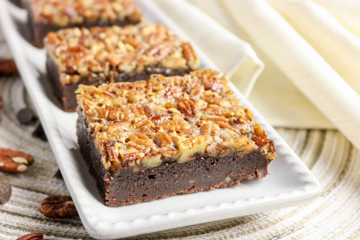 A row of pecan pie brownies showing consistent golden pecan topping on each square - Hostess At Heart