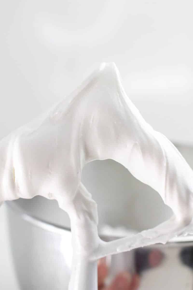 An electric mixer paddle attachment topped with Royal Icing demonstrating it's stiff texture for decorating - Hostess At Heart