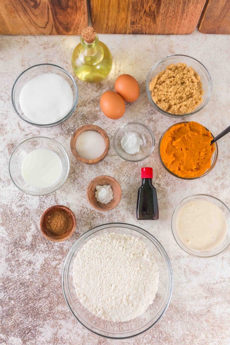 Ingredients for sourdough pumpkin muffins including flour, pumpkin puree, sourdough discard, eggs, and spices on a counter - Hostess At Heart