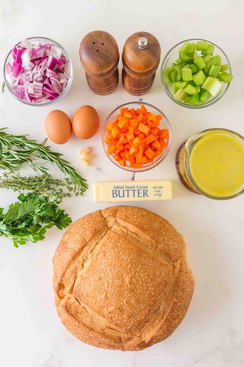 Sourdough Stuffing Recipe Ingredients: A loaf of sourdough, diced onion, carrots, and celery, butter, eggs, salt, pepper, fresh rosemary, parsley, thyme, and chicken broth - Hostess At Heart