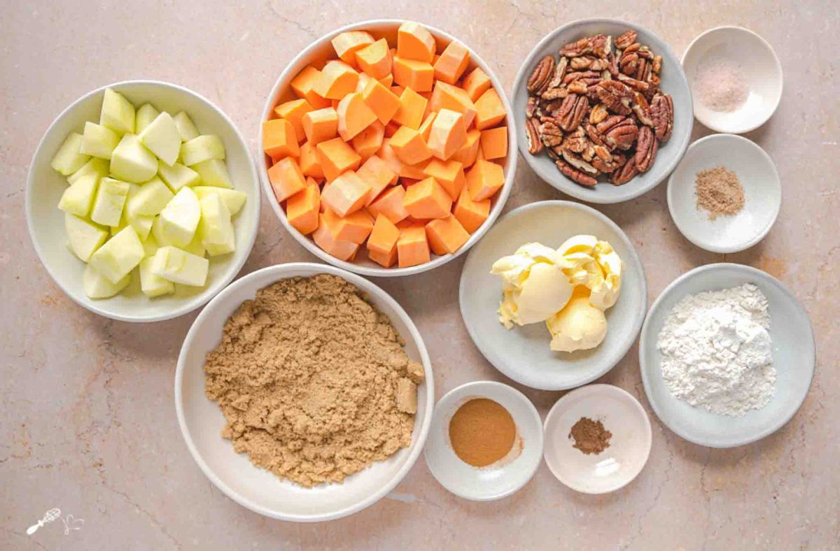 Ingredients for sweet potato apple casserole including pecans, butter, sweet potatoes, green apples, brown sugar, and spices. Hostess At Heart