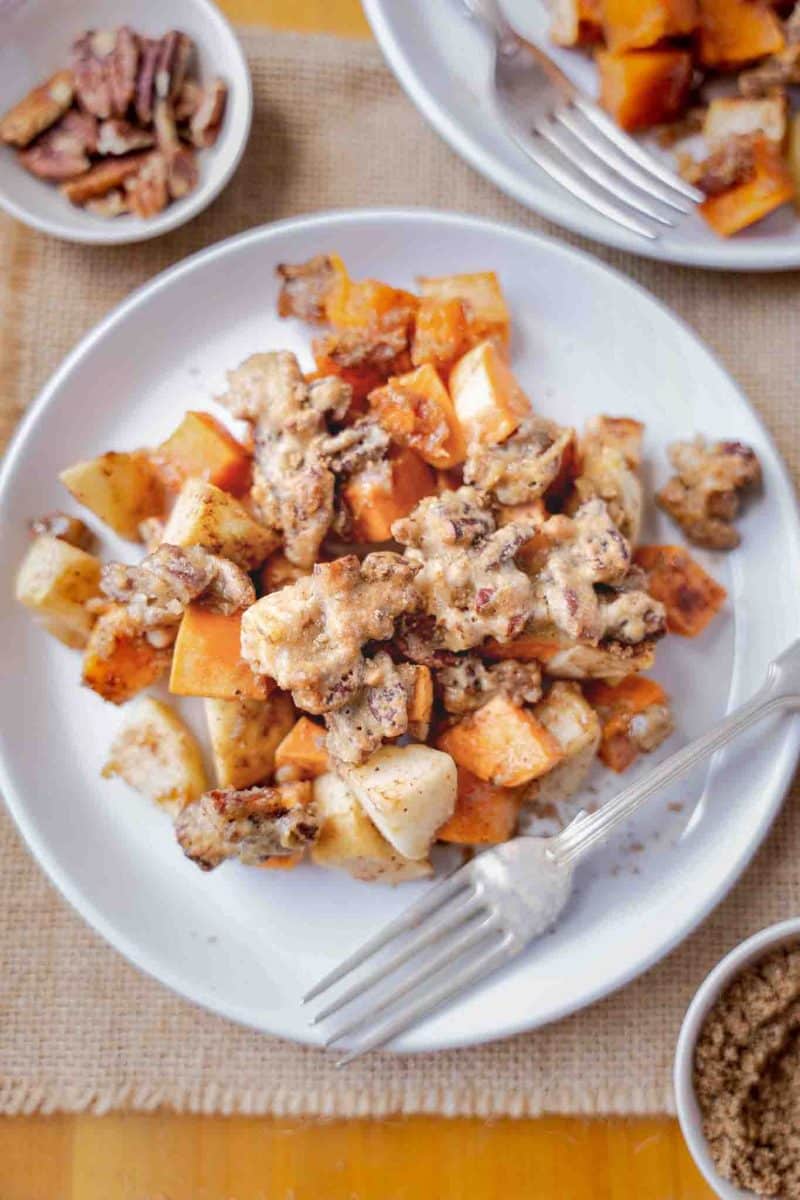 Individual serving of sweet potato apple casserole on white plate with a fork - Hostess At Heart