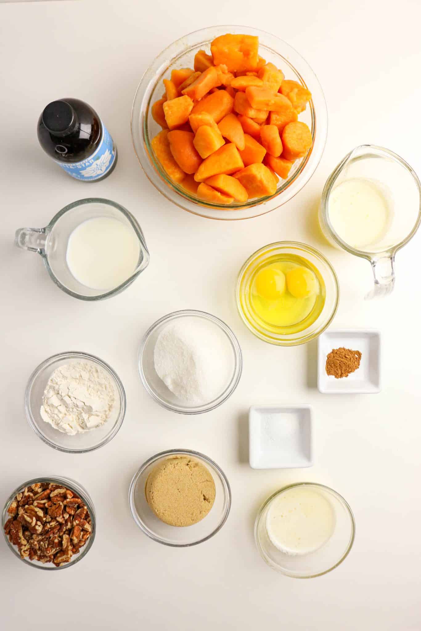 Ingredients for Sweet Potato Casserole made from canned yams: pecans, brown sugar, milk, canned yams, cinnamon, eggs, vanilla, sugar, and salt - Hostess At Heart
