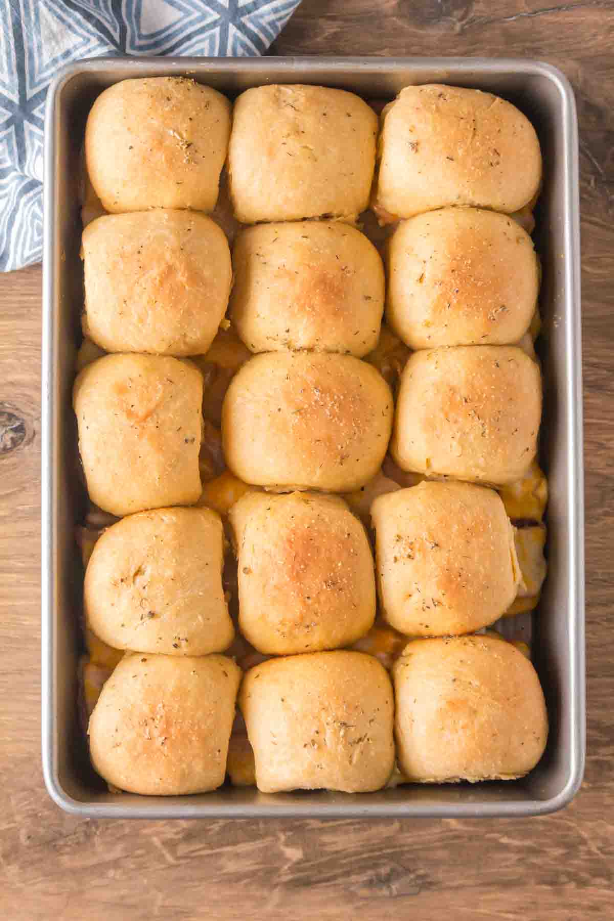 Toop down view of golden brown Hawaiian ham and cheese sliders in a baking pan fresh from the oven. Hostess At Heart