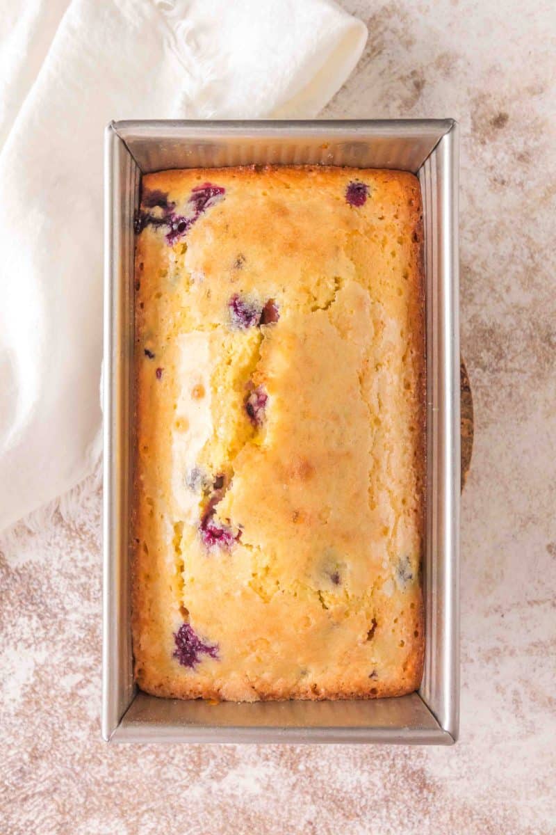 Top down view of a golden brown lemon blueberry sourdough bread fresh from the oven. Hostess At Heart