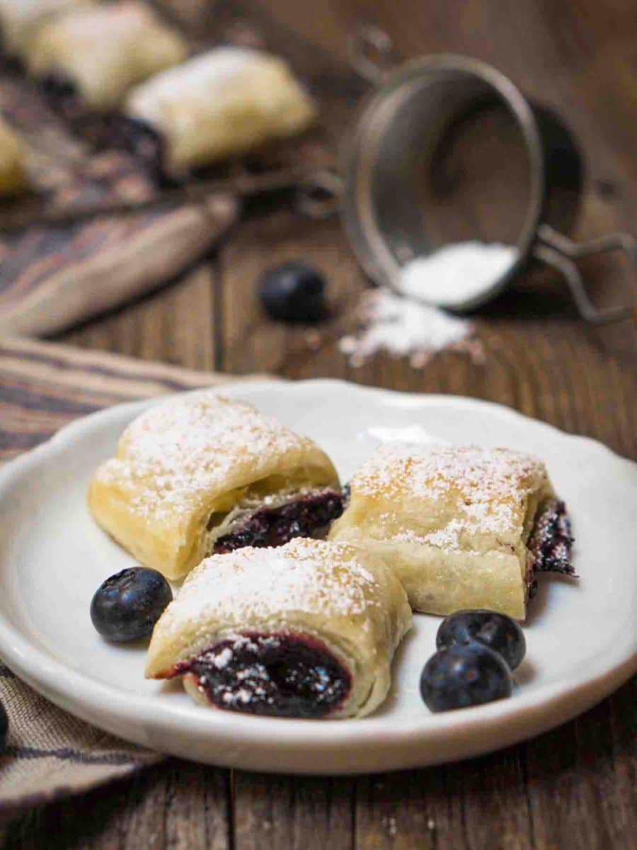 Front view of a beautifully golden brown stack of blueberry puff pastries - Hostess At Heart
