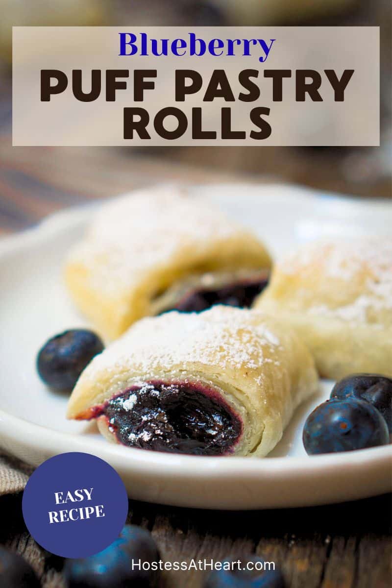 An image for Pinterest of a front view of blueberry filled puff pastries sitting on a white plate - Hostess At Heart