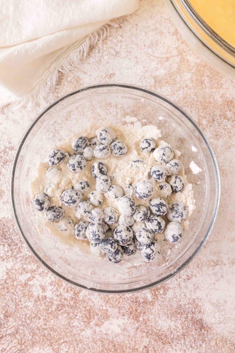 Coating fresh blueberries with flour for lemon blueberry sourdough bread. Hostess At Heart