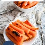 Brown sugar glazed carrots in a white serving dish with orange glaze