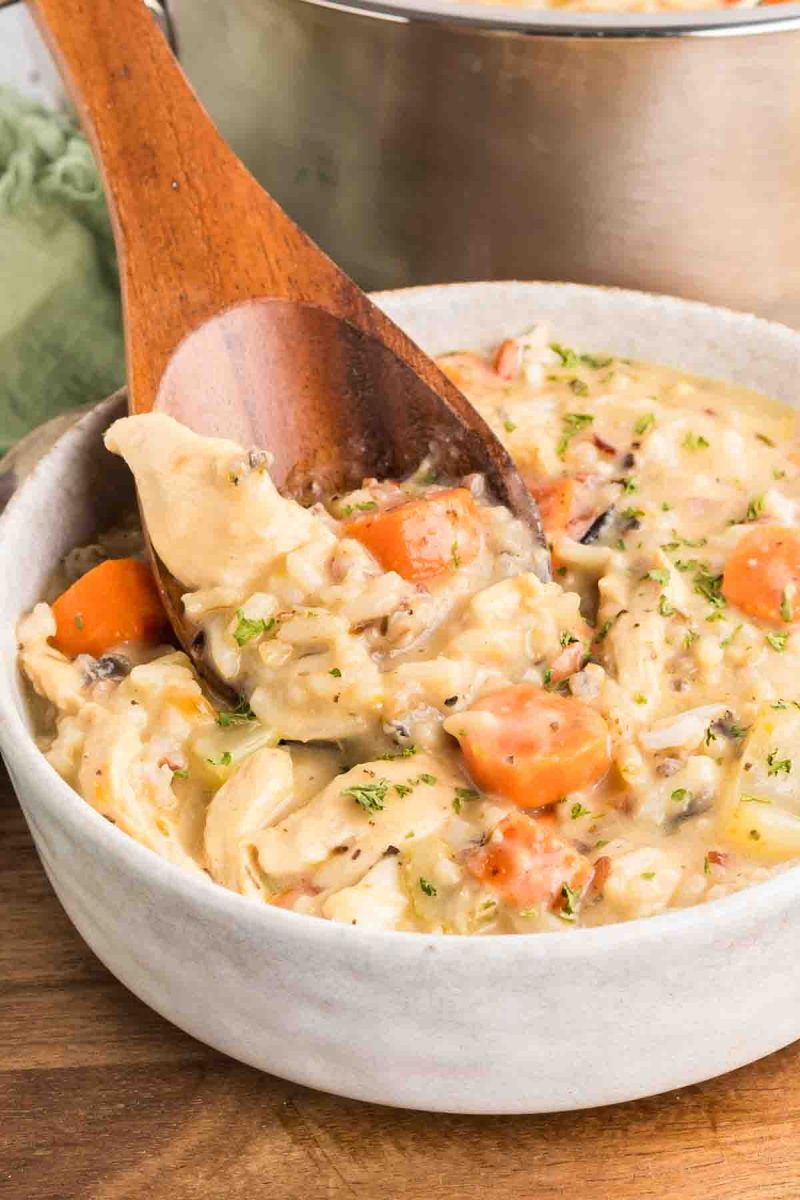 Extreme close-up of chicken and wild rice soup in a bowl showing wild rice and tender chicken pieces in creamy sauce. Hostess At Heart