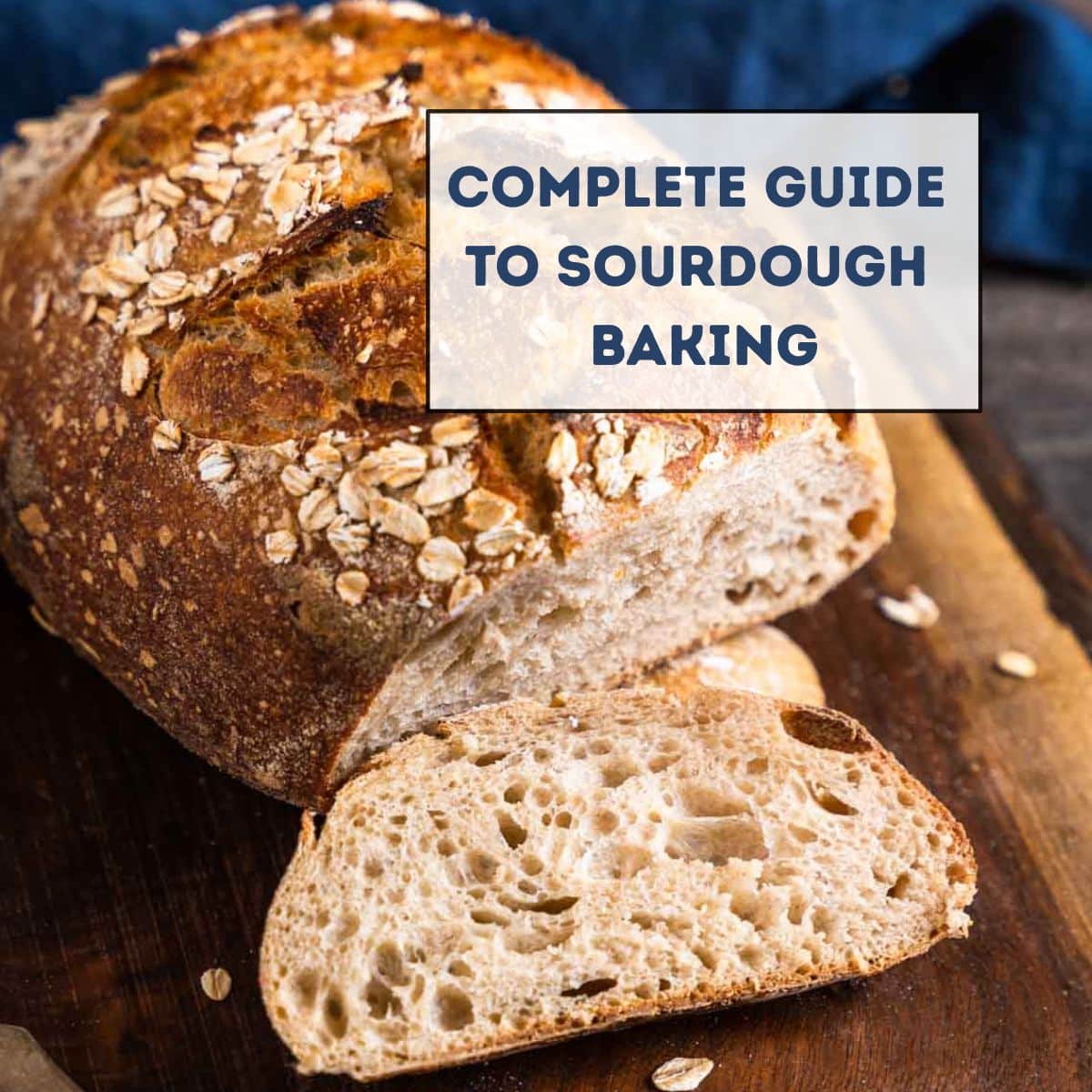 Angled view of a golden brown loaf of rye sourdough bread. The front is cut off showing a soft and fluffy open crumb. The post title is on the image - Hostess At Heart