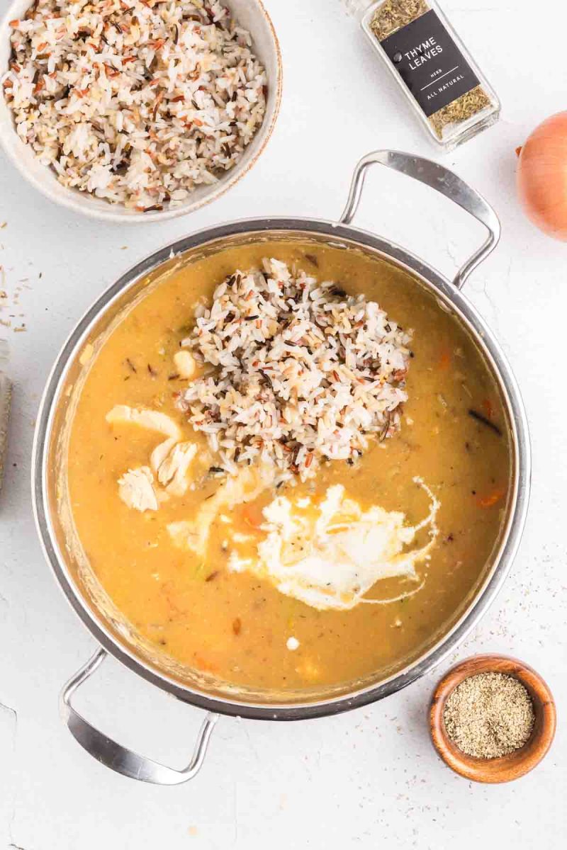 Warmed heavy cream and cooked wild rice added into pot of chicken and wild rice soup creating creamy swirls in the broth. Hostess At Heart