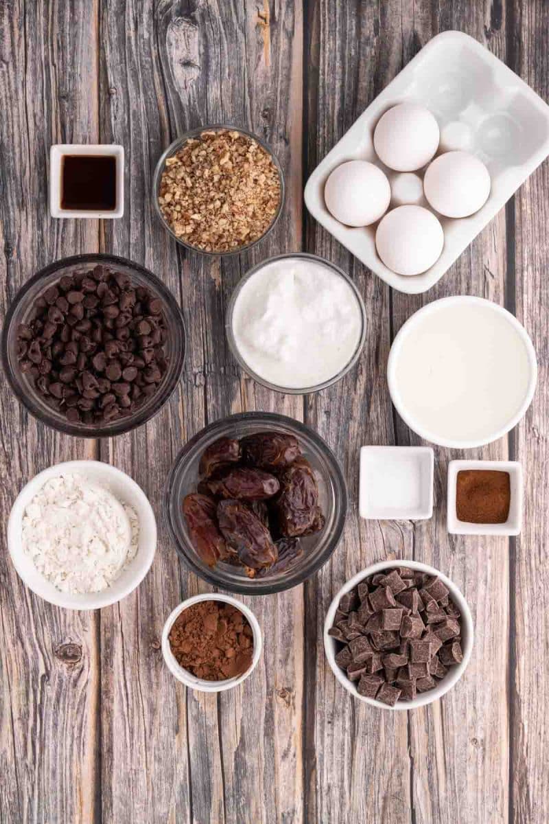 Ingredients for gluten-free brownies including dates, eggs, chocolate chips, unsweetened cocoa, GF flour, espresso powder, and coconut oil. Hostess At Heart