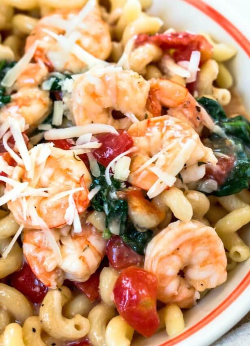 Top down view of a bowl of healthier shrimp pasta loaded with jumbo shrimp, tomatoes, and fresh spinach - Hostess At Heart