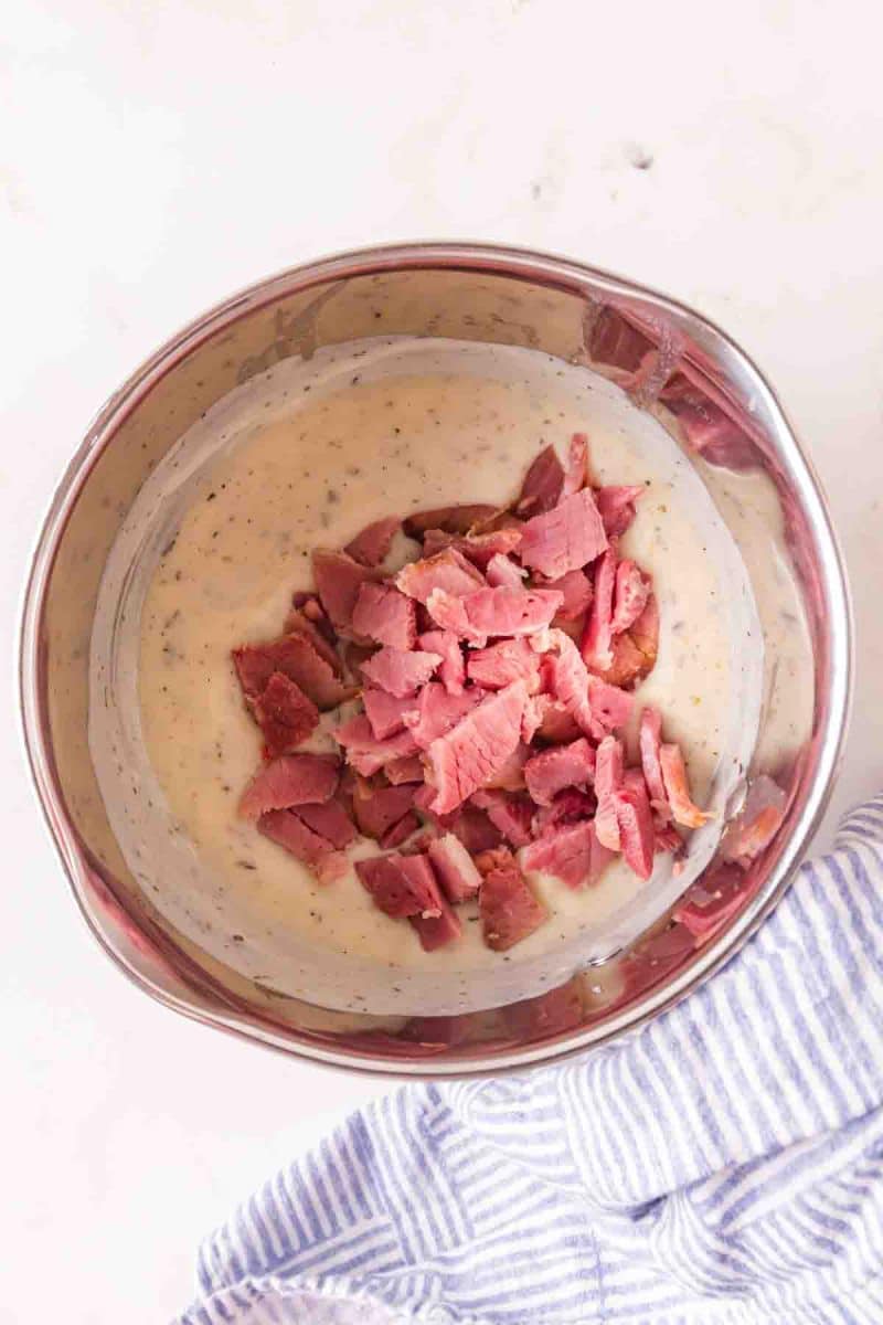 Diced leftover ham being added into creamy sauce - Hostess At Heart