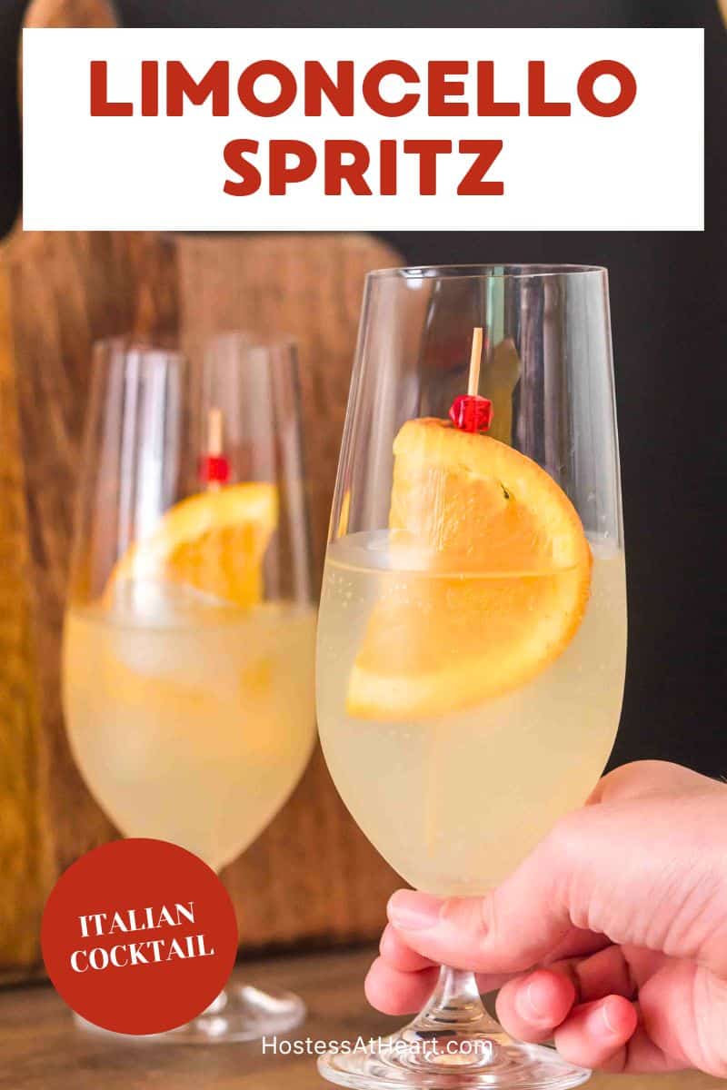 2 finished Limoncello Spritz cocktails in champagne glasses garnished with a orange wheel and, showing the pale yellow bubbly drink - Hostess At Heart
