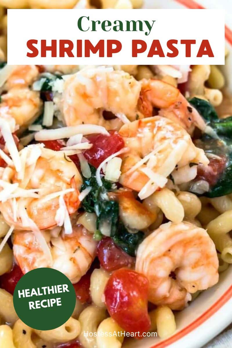Image for Pinterest. Top down view of a bowl of Cavatappi pasta loaded with jumbo shrimp, tomatoes, and fresh spinach - Hostess At Heart
