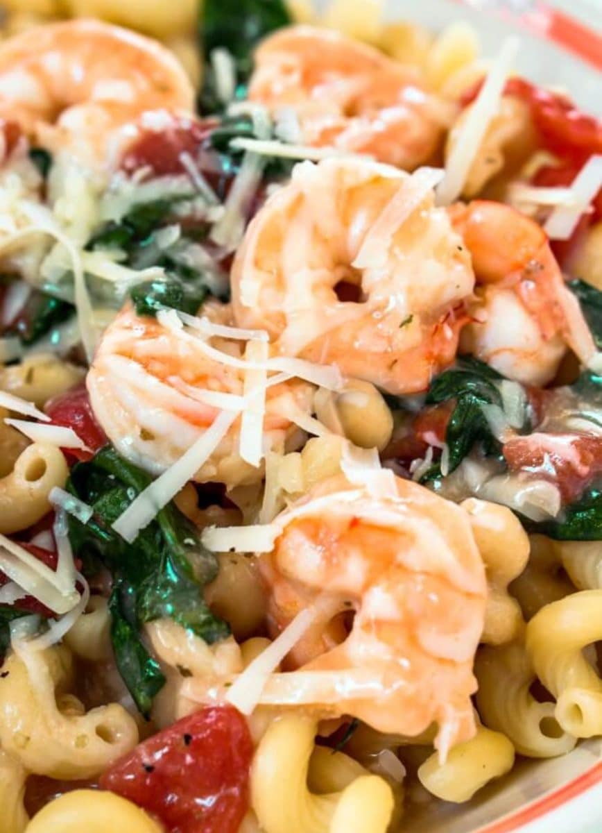 Top down view of a bowl of creamy shrimp pasta loaded with jumbo shrimp, tomatoes, Cavatappi pasta, and fresh spinach - Hostess At Heart